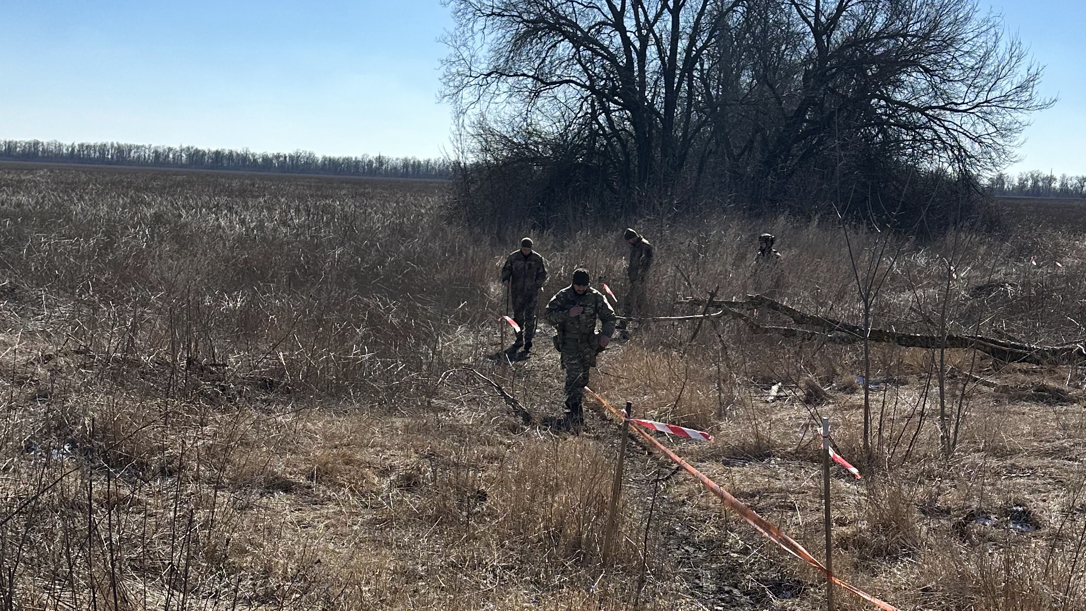 IGR personnel and Ukrainian Police EOD specialists moving through a marked area in Chuhuiv District