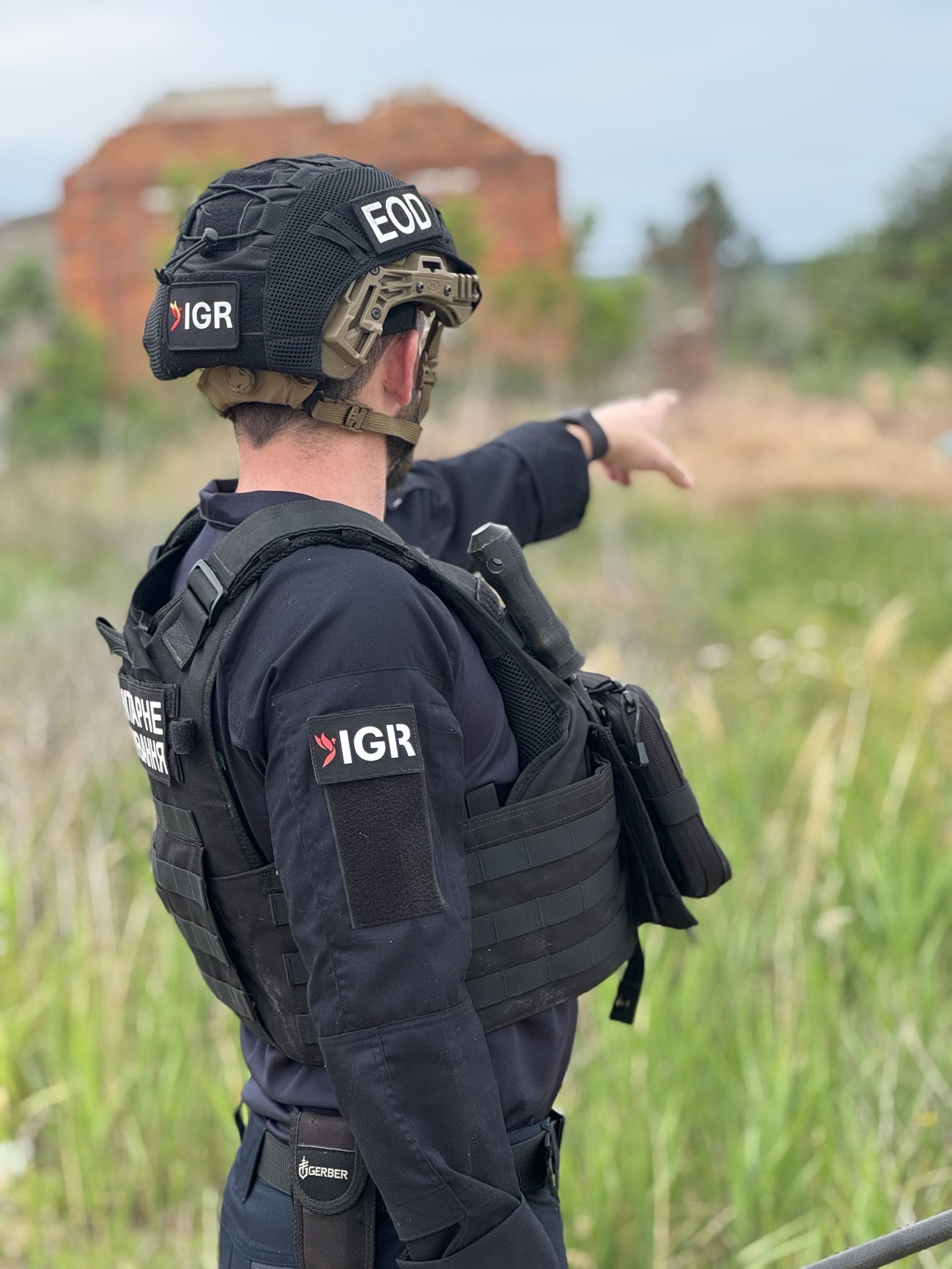 An IGR team member pointing across a field during an operation
