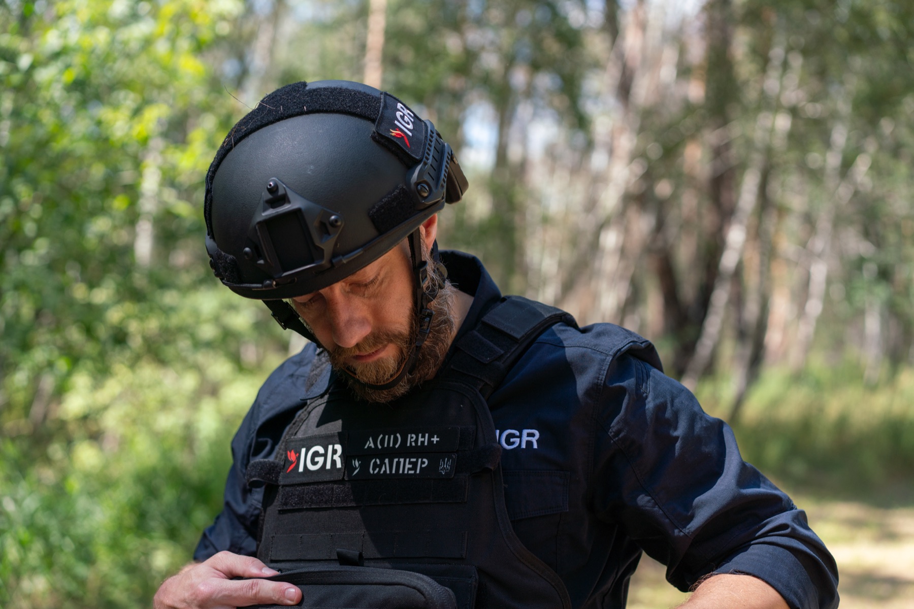 An IGR specialist preparing protective equipment in the field