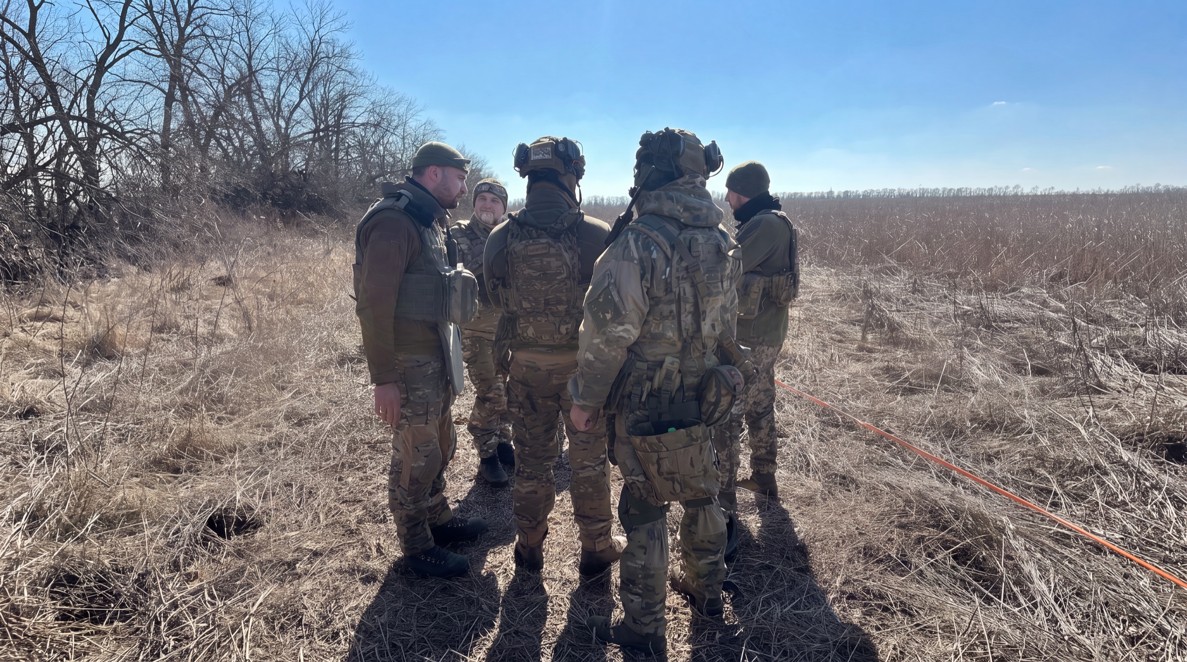 IGR personnel working with Ukrainian police EOD specialists in a marked field in Kharkiv Oblast